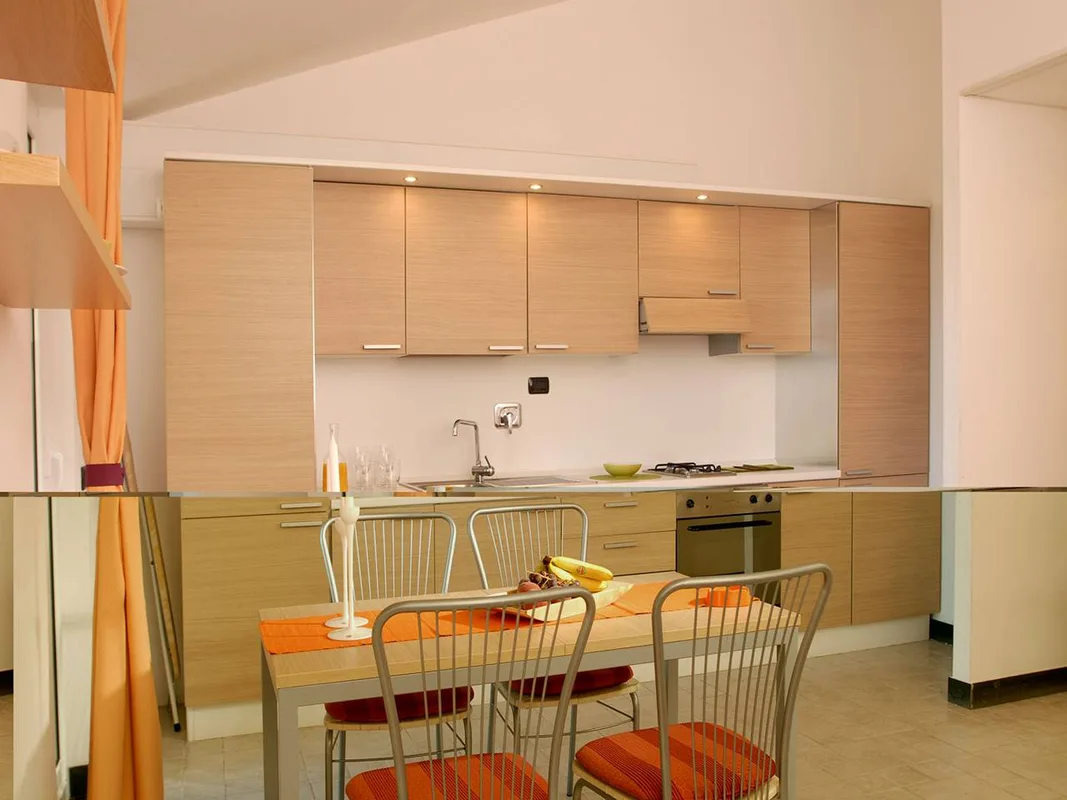 Cucina moderna in legno chiaro con tavolo da pranzo e sedie