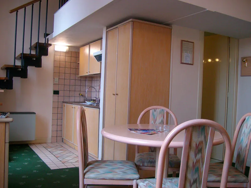 Appartamento su due livelli con scala a chiocciola, cucina e tavolo da pranzo
