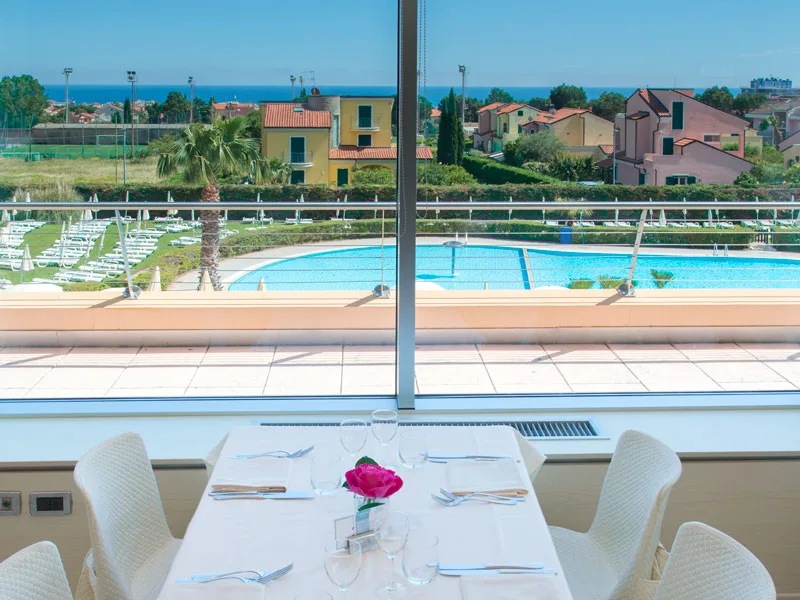 Tavolo apparecchiato con vista sulla piscina e sul mare