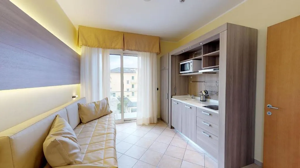 Monolocale con divano, angolo cottura con microonde e balcone