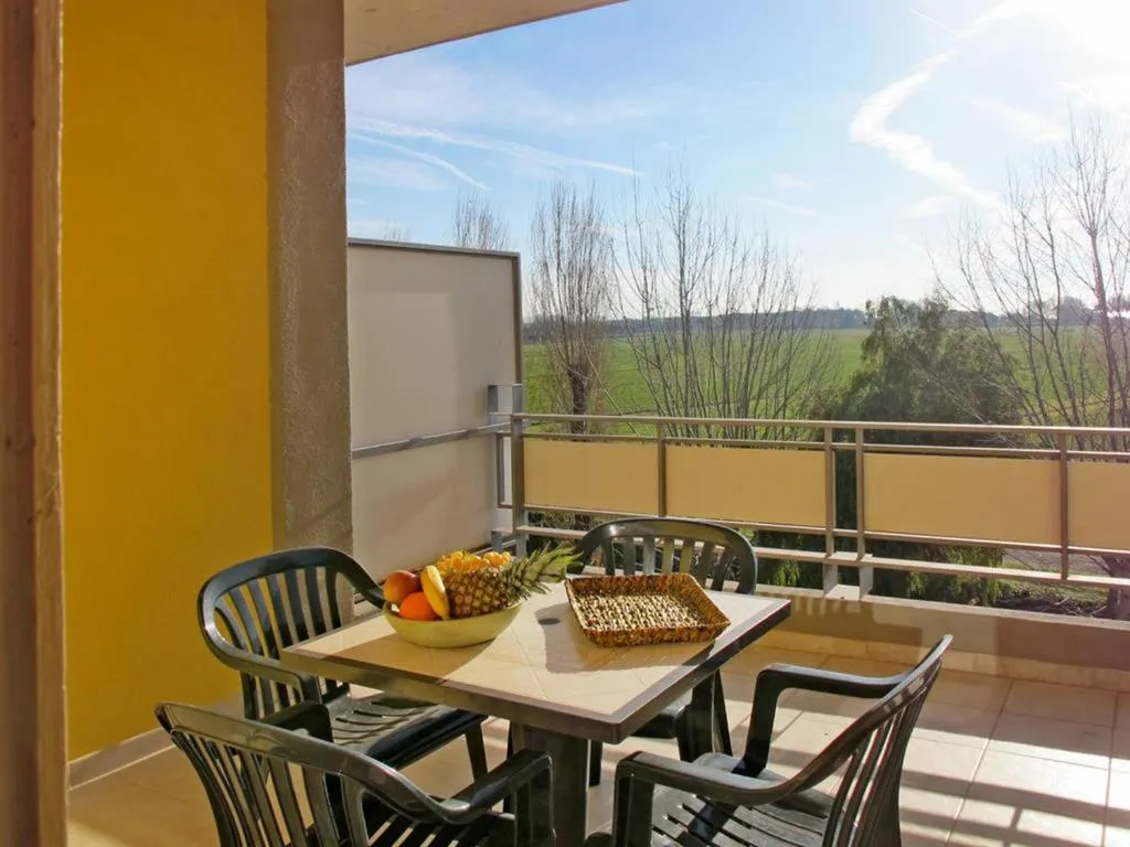 Terrazza con tavolo e sedie affacciata su campagna verde e cielo azzurro