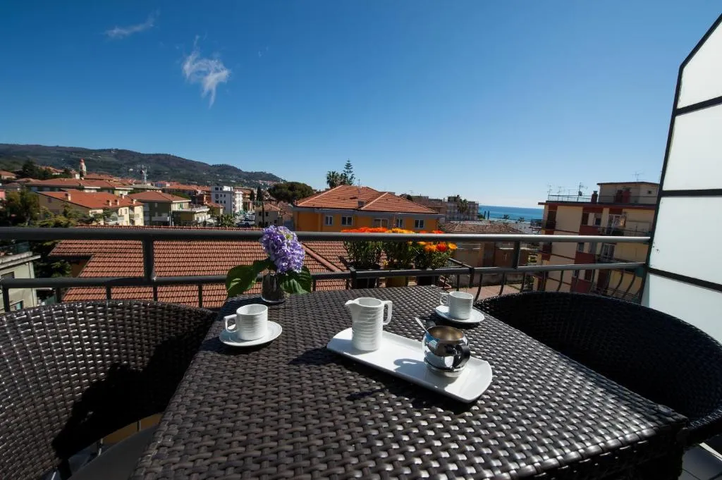 Balcone con tavolino, caffè e vista sui tetti e sul mare