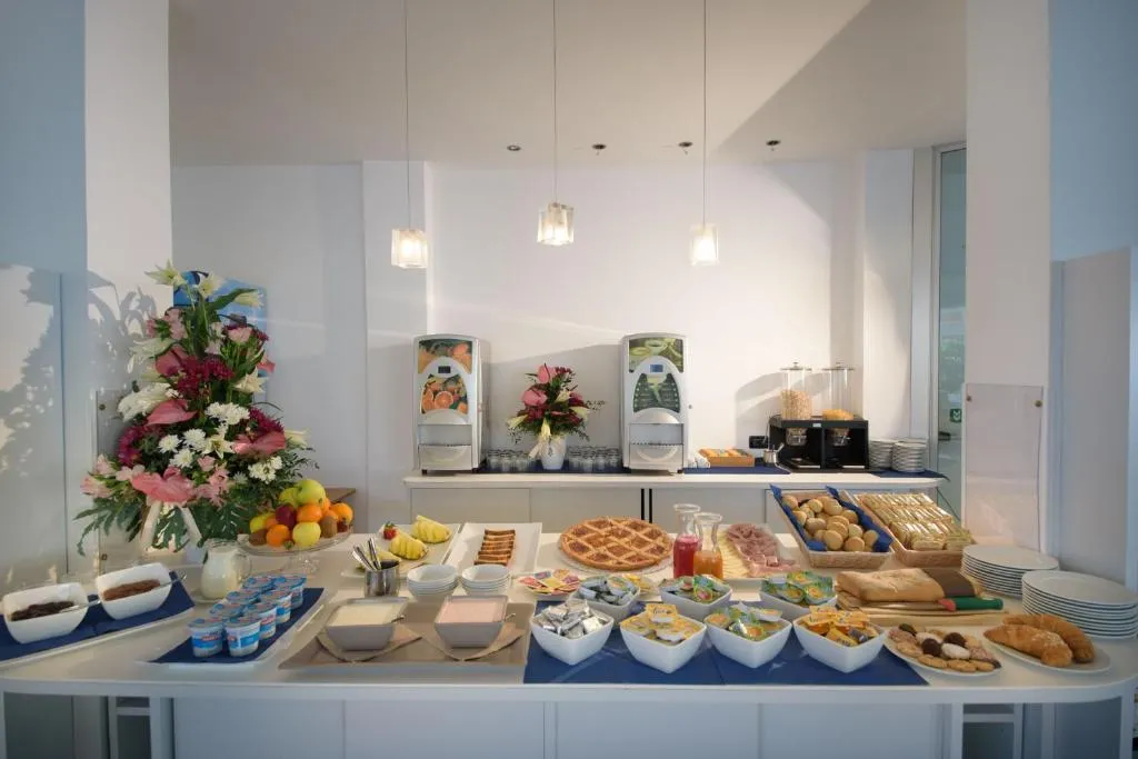 Buffet della colazione con dolci, pane, yogurt e distributori di bevande