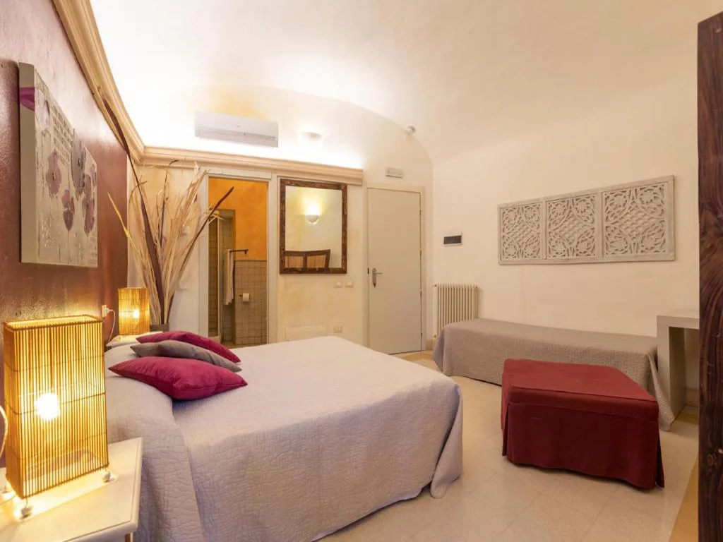 Camera tripla con letto matrimoniale, letto singolo e dettagli rosso bordeaux