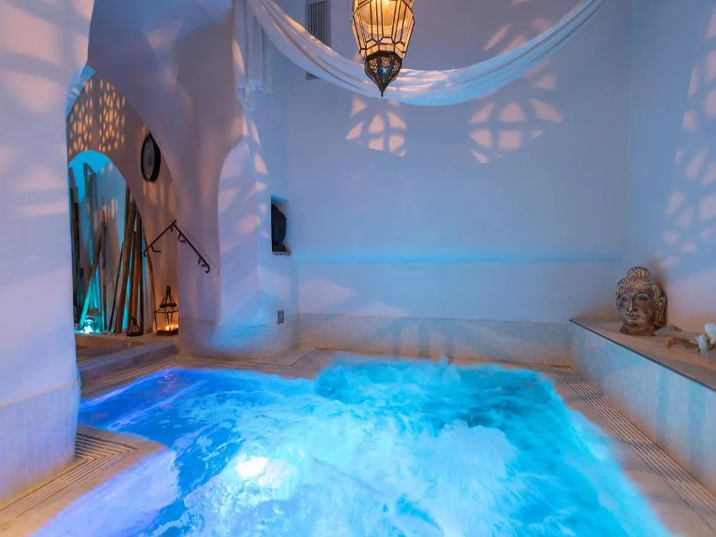 Vasca idromassaggio spa con luce azzurra, lanterna e decorazione buddha