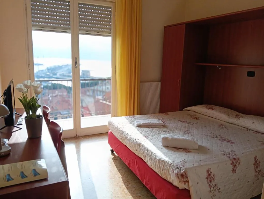 Camera con letto matrimoniale, scrivania e finestra con vista sul mare