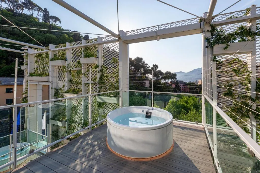 Vasca idromassaggio su terrazza panoramica circondata da pergolato bianco e vegetazione