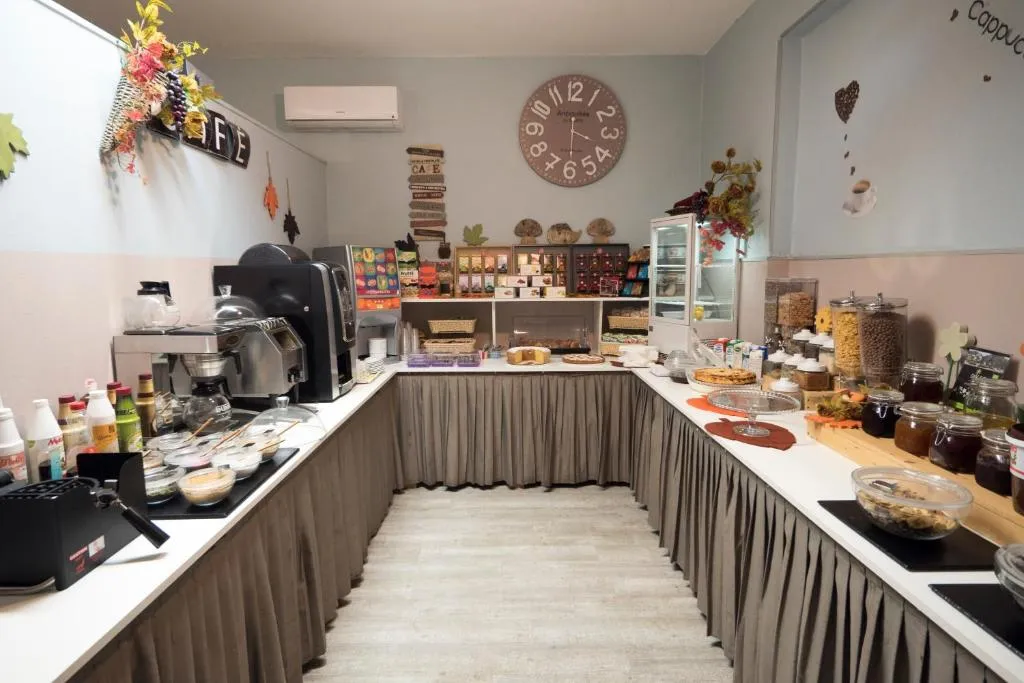 Sala colazione con buffet, macchina del caffè e torte