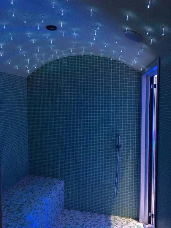 Bagno turco con rivestimento a mosaico azzurro, soffitto a stelle luminose e seduta