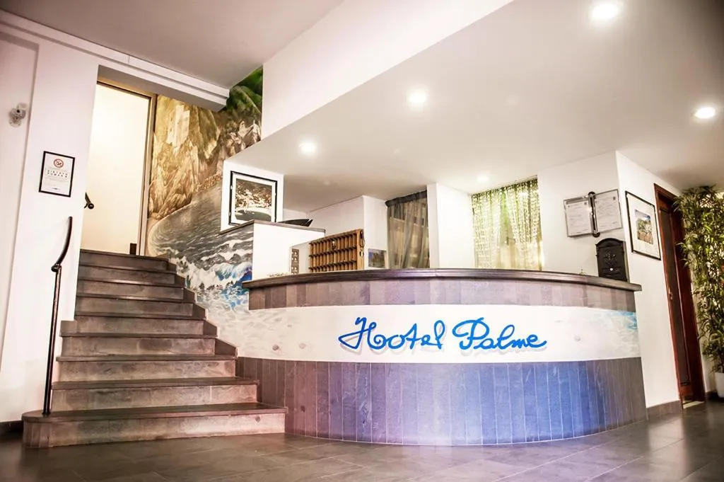Reception dell'Hotel Palme con bancone decorato e scala in legno