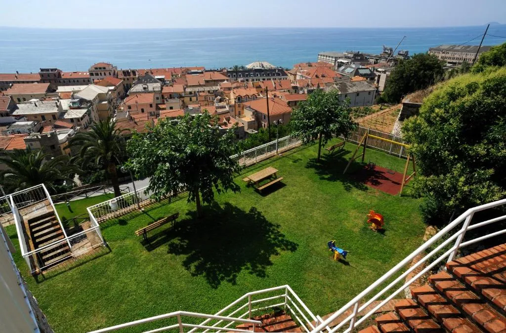 Vista panoramica del giardino con area giochi e paesaggio sul mare e paese