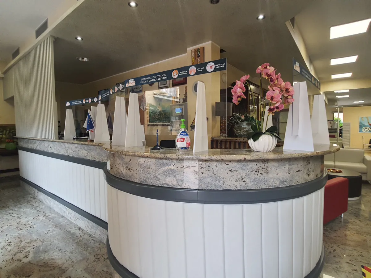 Reception dell'hotel con bancone in marmo e orchidea decorativa