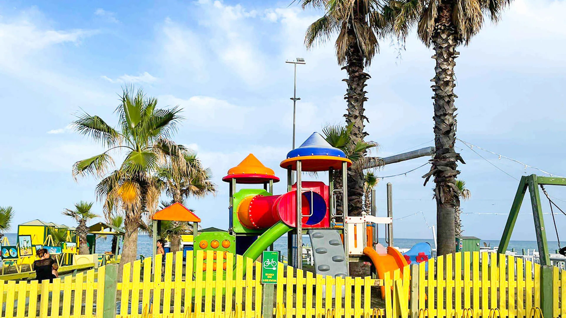 Area giochi per bambini colorata con palme sulla spiaggia
