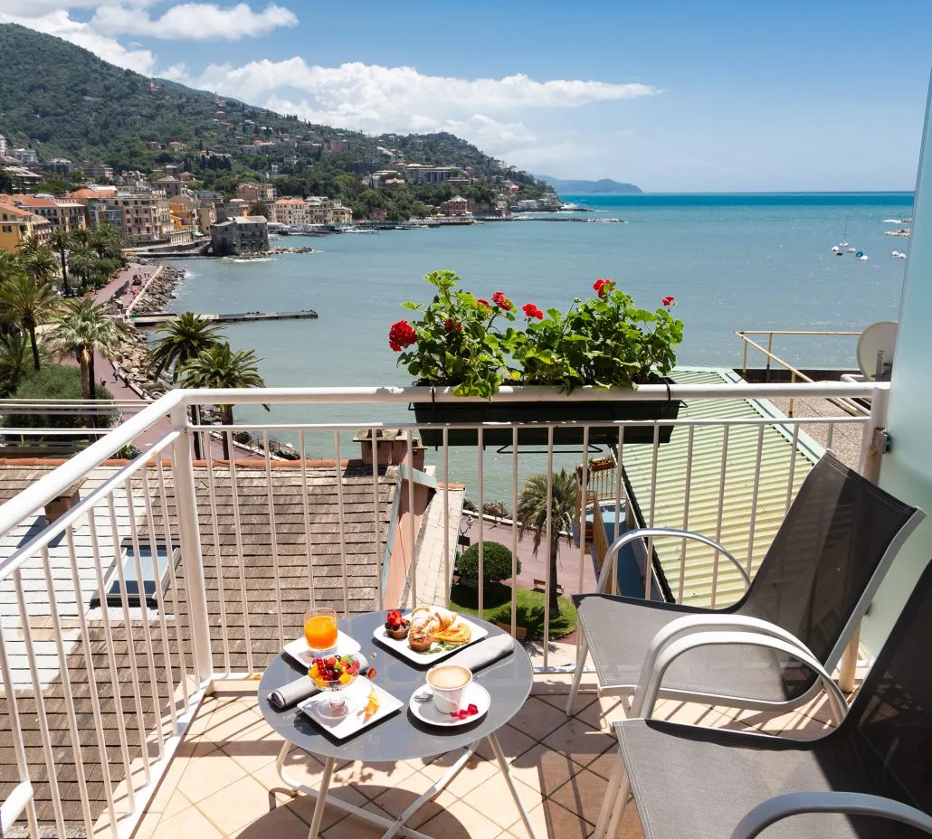 Balcone con tavolino da colazione e vista spettacolare sul mare e sulla costa ligure