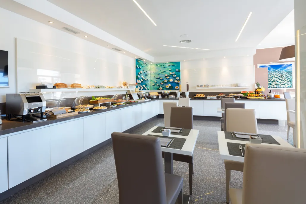 Sala colazione con ricco buffet, tavoli apparecchiati e ambiente luminoso