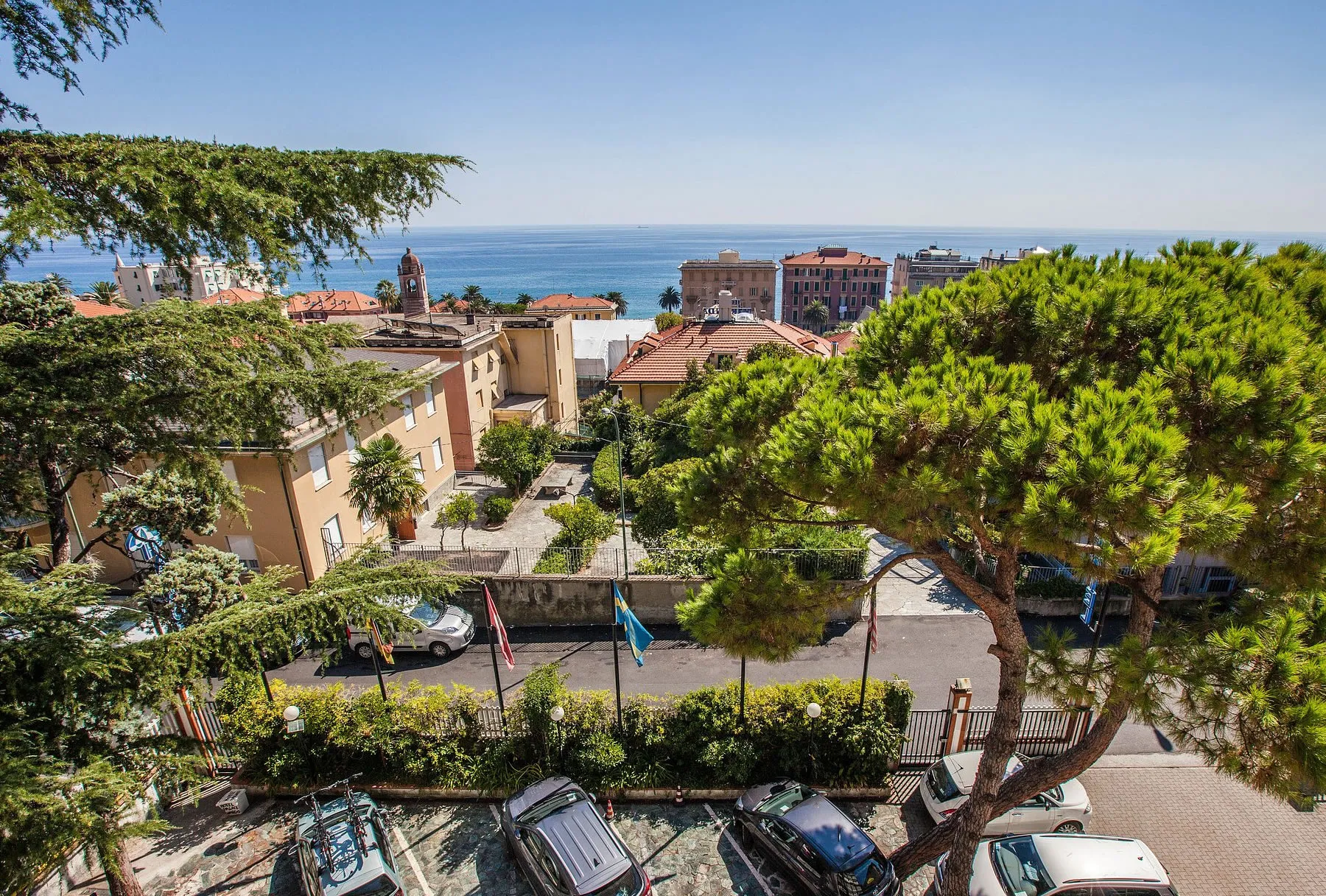 Panorama sui tetti del borgo, sul campanile e sul mare con vegetazione in primo piano