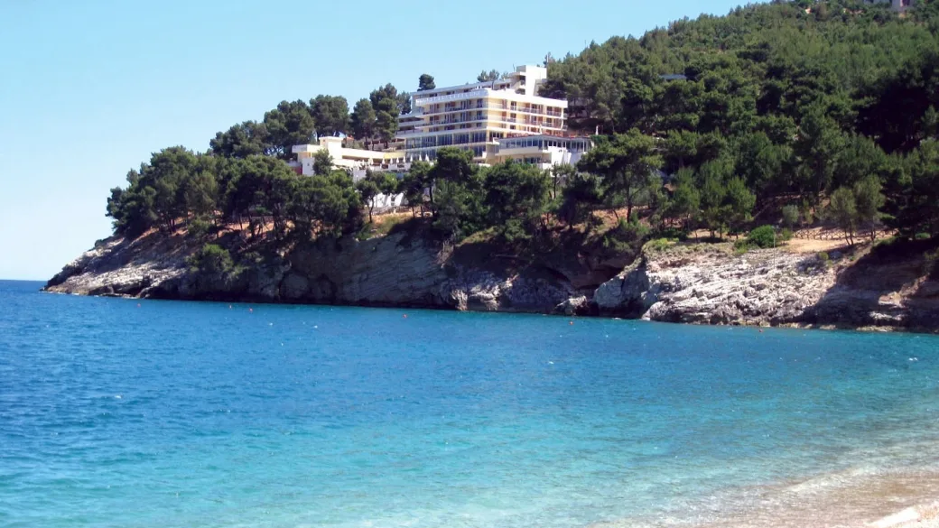 Hotel bianco su promontorio panoramico immerso tra i pini affacciato sul mare turchese
