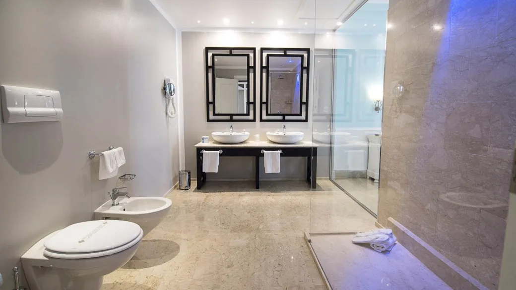 Bagno spazioso con doppio lavabo, specchi neri, bidet e doccia in vetro