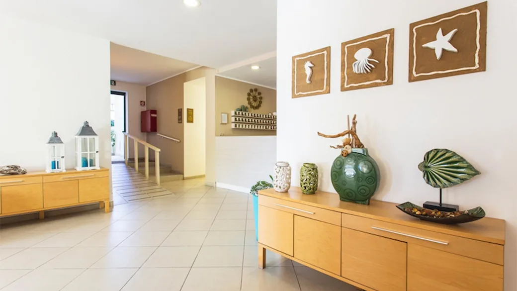 Ingresso interno con mobili in legno e decorazioni a tema marino