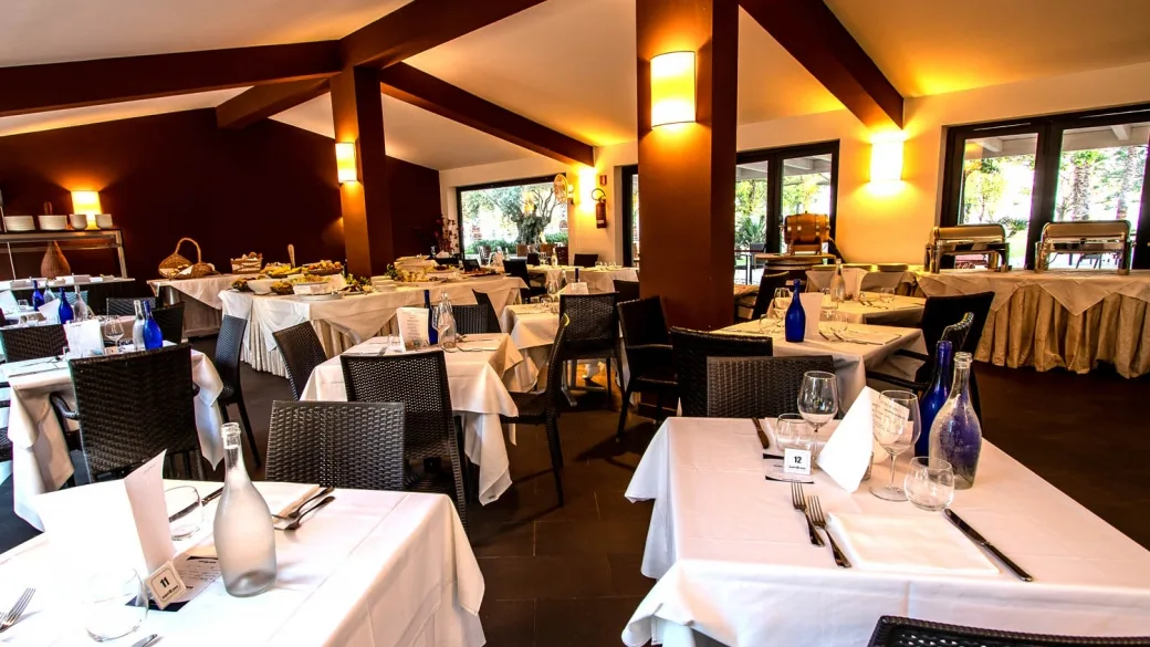 Sala ristorante interna con tavoli apparecchiati e buffet