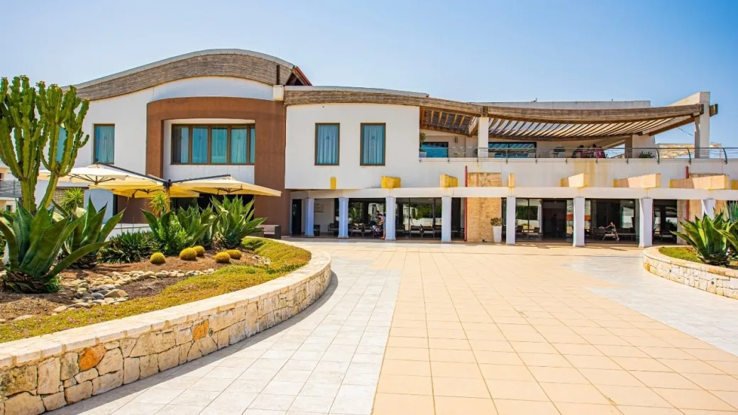 Facciata moderna dell'edificio principale del resort con piazzale e giardino