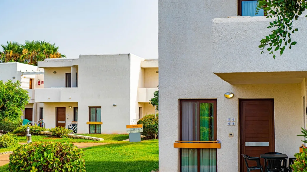 Villette bianche del resort immerse nel verde con giardino curato