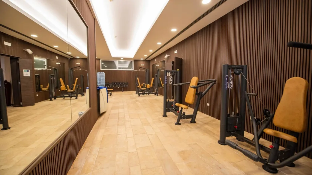 Sala fitness attrezzata con macchine isotoniche e specchi