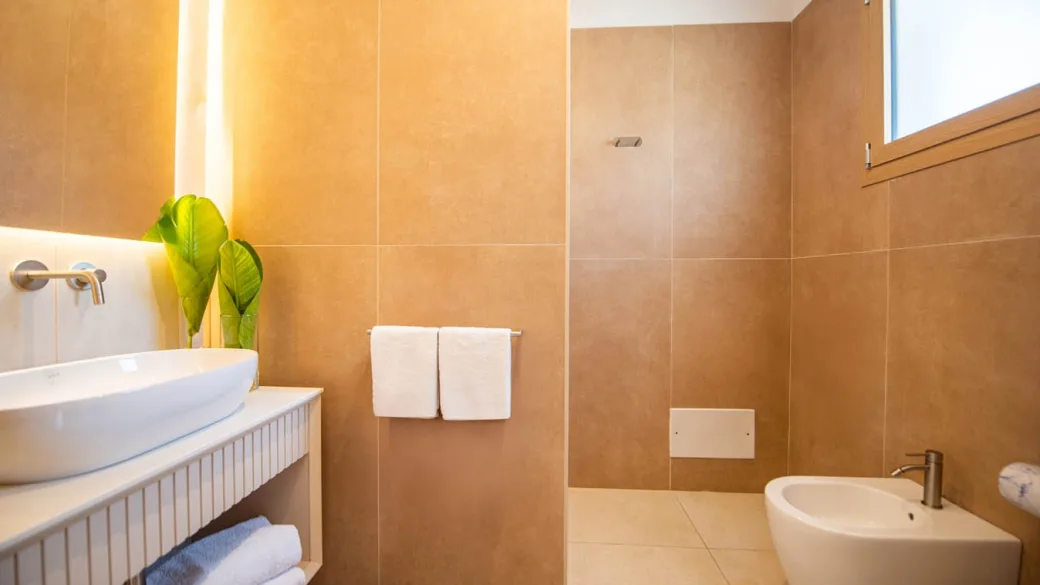 Bagno moderno con lavabo d'appoggio, doccia a pavimento e bidet