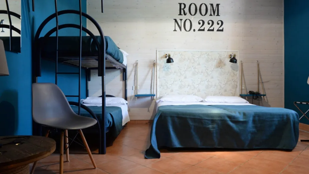 Camera tematica numero 222 con letto a castello, letto matrimoniale e pareti blu
