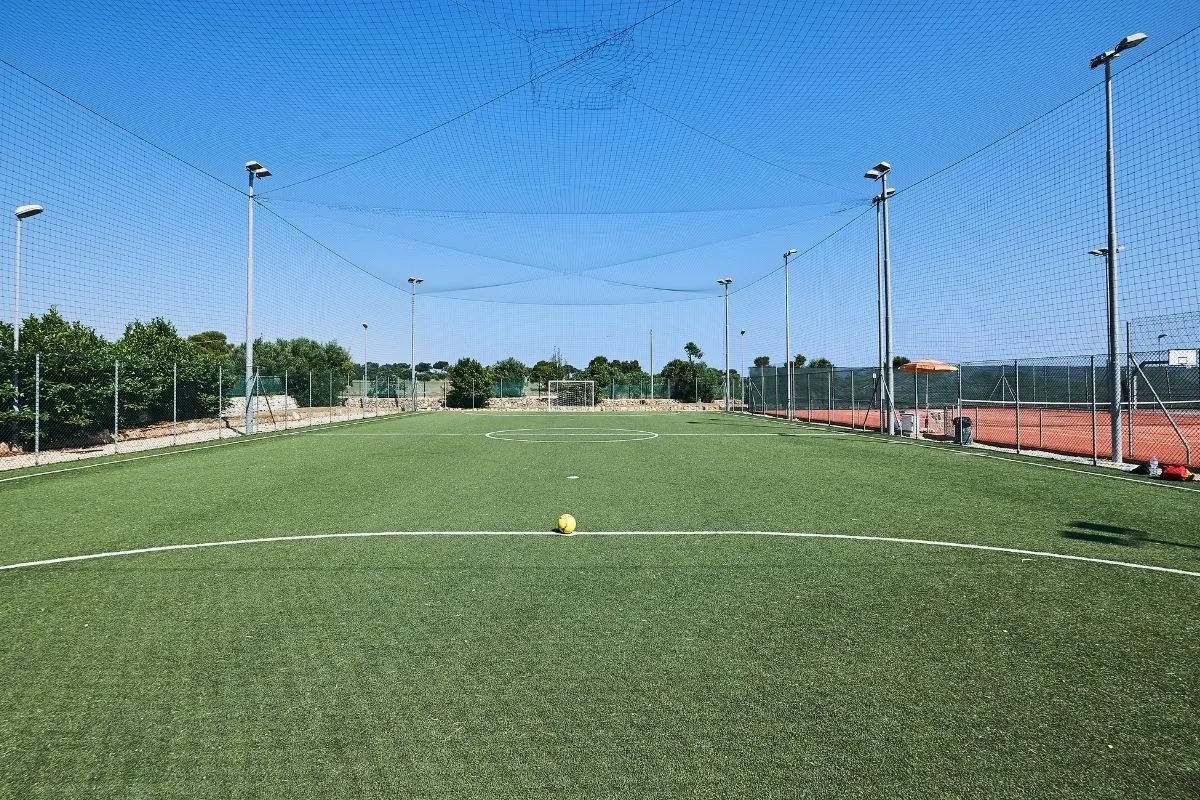Campo da calcetto in erba sintetica con rete di recinzione