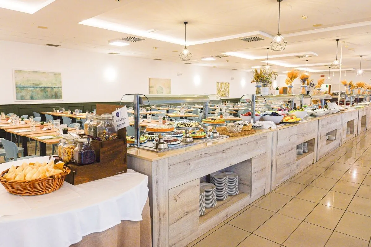 Sala ristorante con ampio buffet di dolci, frutta e specialità