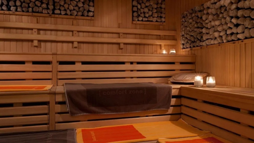 Interno di sauna in legno con asciugamani e candele accese