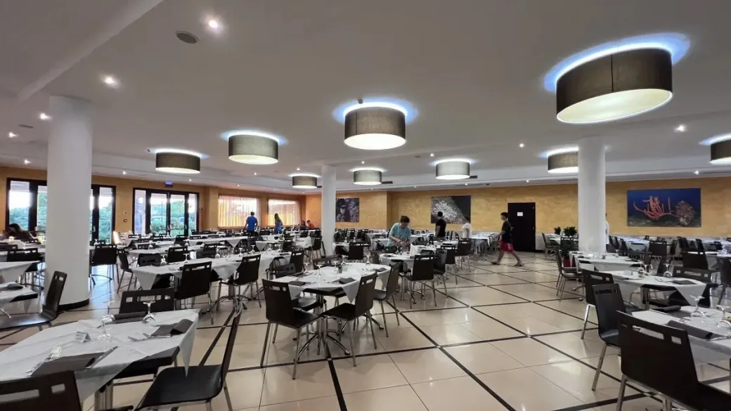 Sala ristorante interna con tavoli apparecchiati e lampade sospese