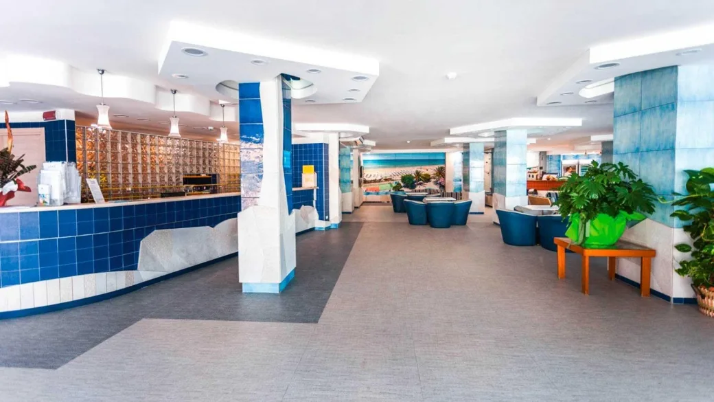 Reception e hall dell'hotel con banco rivestito in piastrelle blu e area lounge