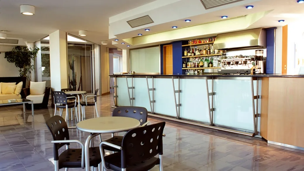 Bar interno dell'hotel con bancone, tavolini e area lounge