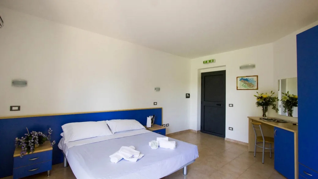 Camera matrimoniale con letto, scrivania e arredi blu