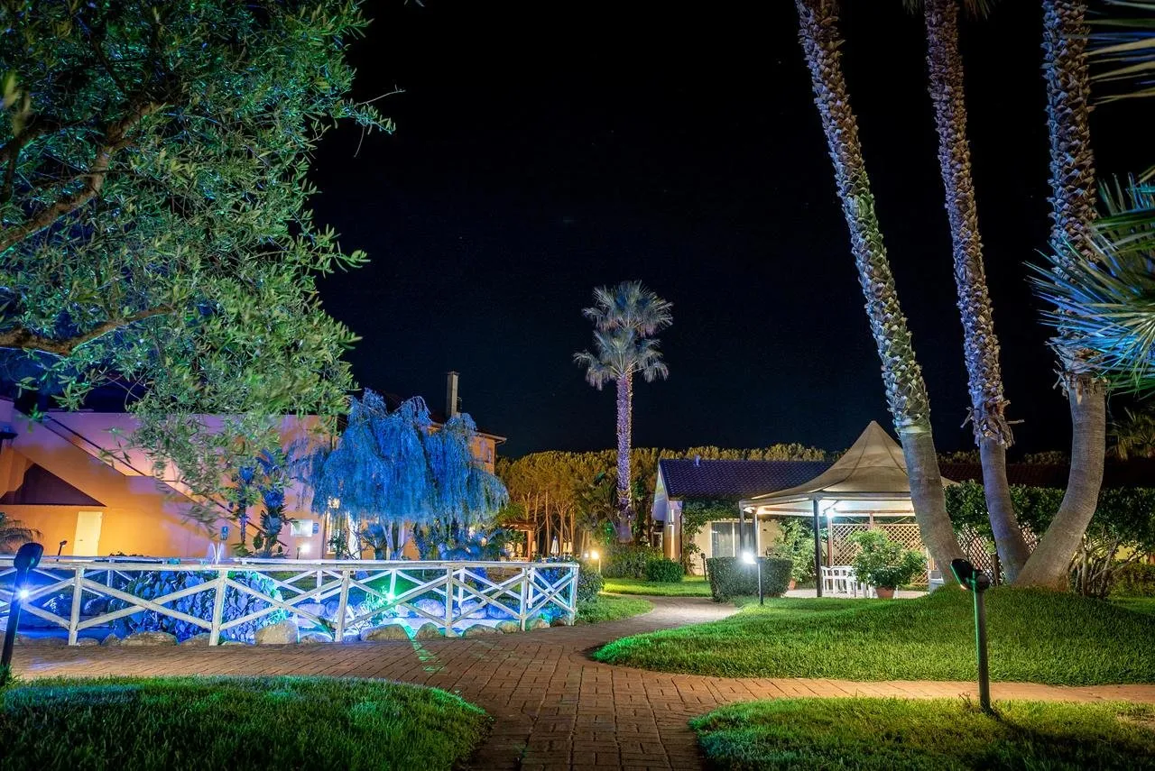Giardino del resort illuminato di notte con palme e percorso pedonale