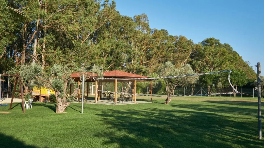 Area verde con gazebo in legno, campo da gioco e alberi ombrosi