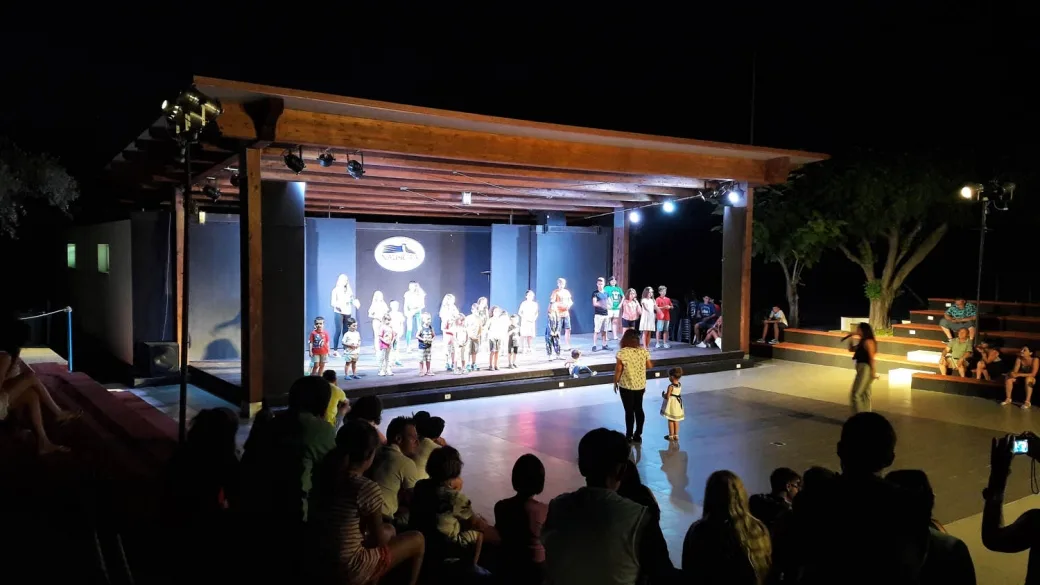 Spettacolo serale sul palco dell'anfiteatro con pubblico di famiglie