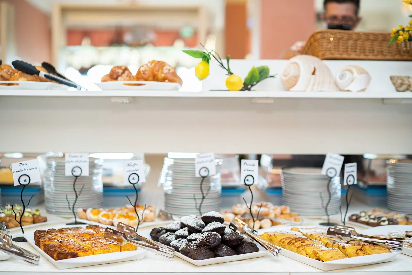Buffet della colazione con dolci, torte e piatti impilati