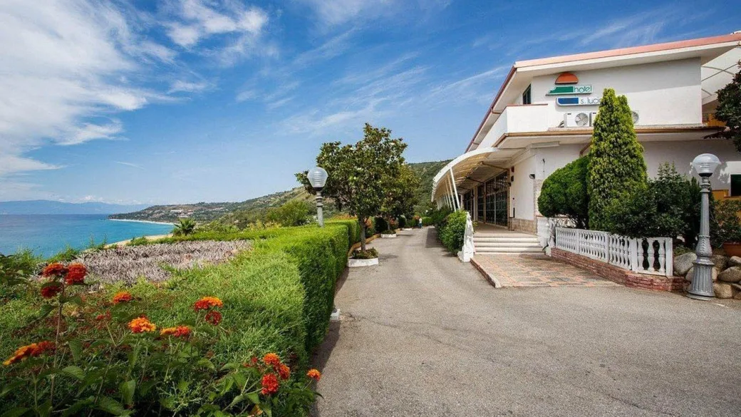 Ingresso dell'hotel Santa Lucia con giardino fiorito e vista mare