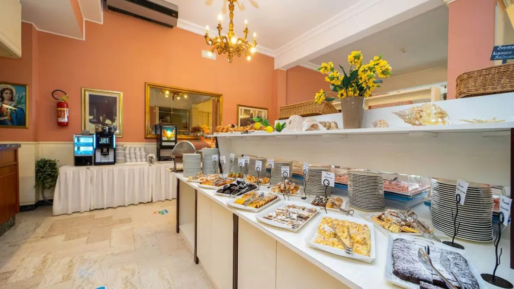 Buffet della colazione con dolci e macchina del caffè in sala colazione