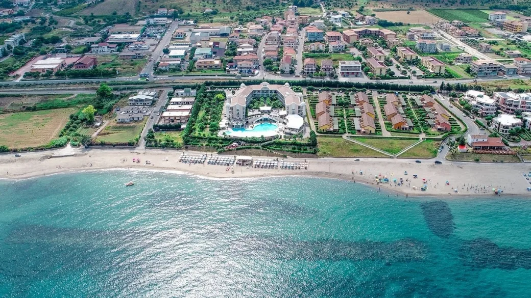 Panorama aereo del resort con piscina e spiaggia attrezzata sul mare