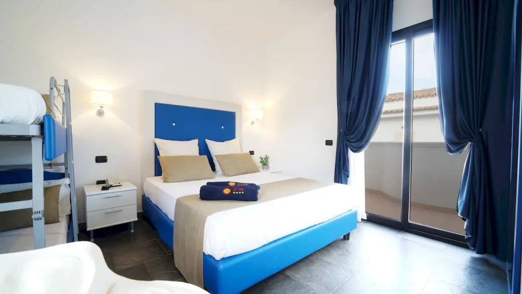 Camera con letto matrimoniale, testiera blu e letto a castello