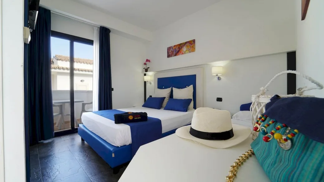 Camera con letto matrimoniale dai dettagli blu e accesso al balcone