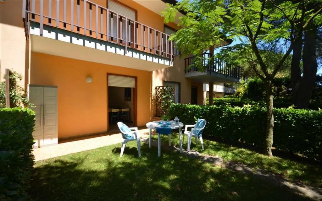 Esterno di un appartamento con giardino privato, tavolo e sedie