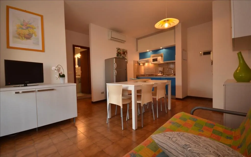 Zona giorno con TV, tavolo da pranzo e angolo cottura