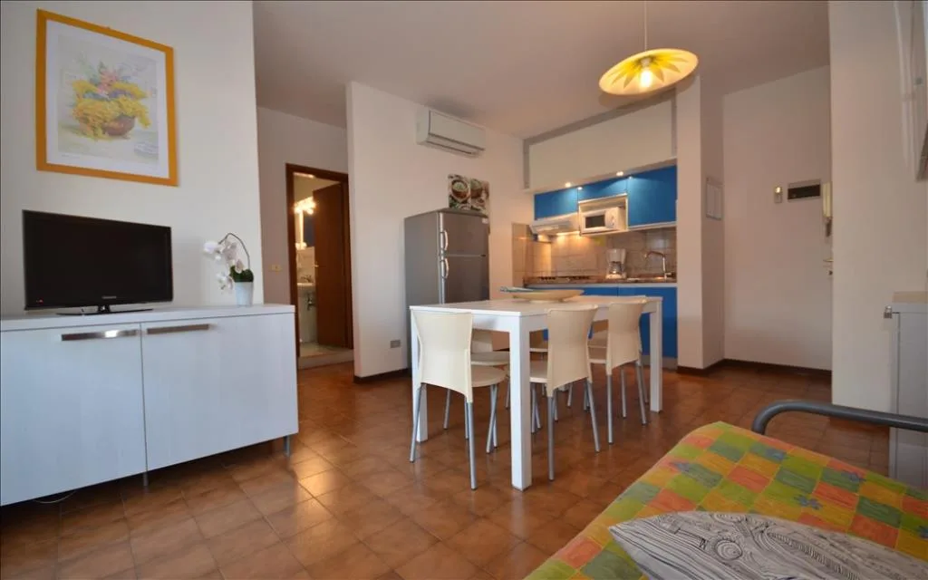 Soggiorno con cucina blu e tavolo bianco