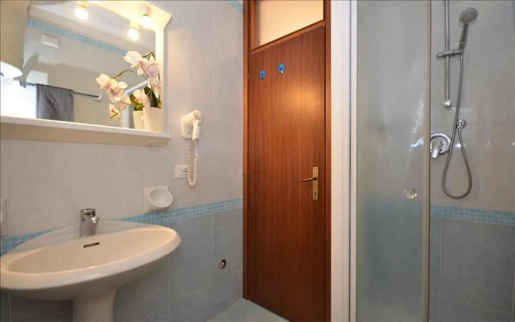 Bagno con doccia, lavabo e specchio