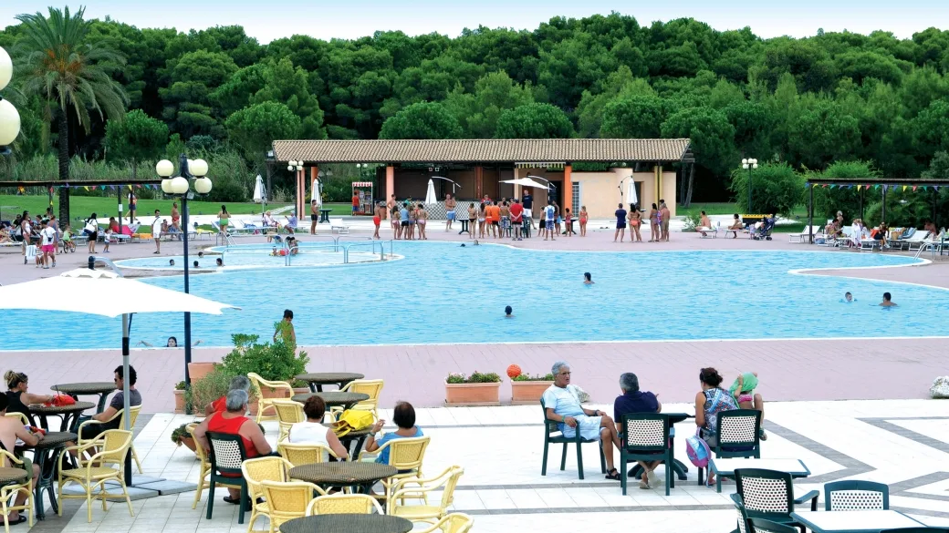 Terrazza con tavoli e sedie affacciata sulla piscina del resort